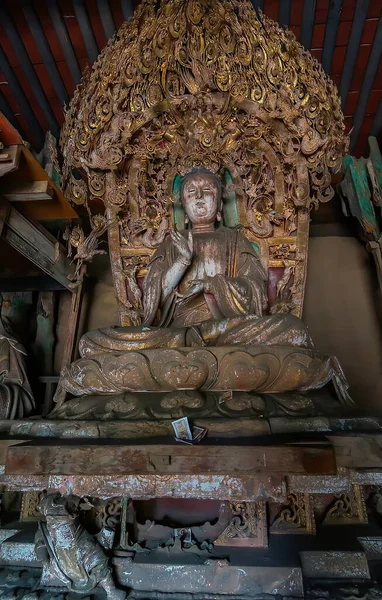 Tahtaya oyulmuş detaylarla birlikte antik sunaktaki Buda heykeli. Shuanglin Tapınağı 'nda (veya Zhongdu Tapınağı) bulunan sunak figürü, Pingyao Eski Şehir, Shanxi, Çin