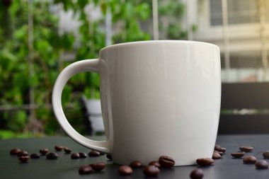 Koyu ahşap masada Kahve Kap birçok kahve çekirdekleri var.