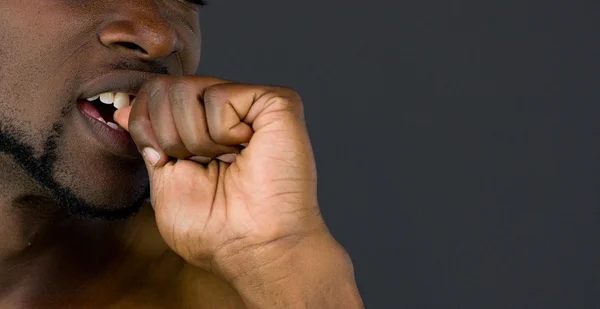 african american man biting nails