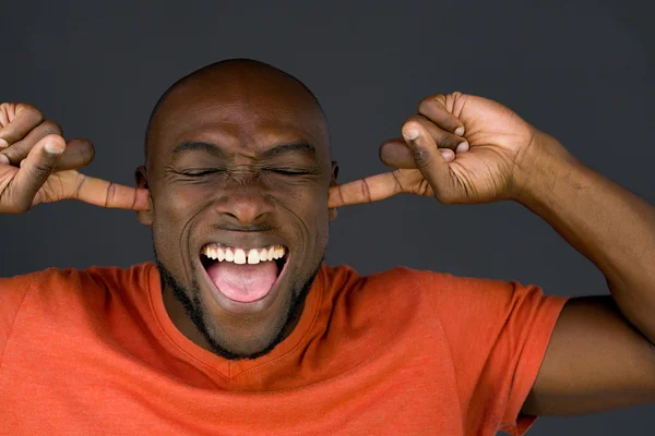 Africano americano hombre taponamiento orejas — Foto de Stock