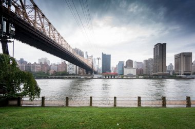 View of Queensboro Bridge with the river and skyline clipart