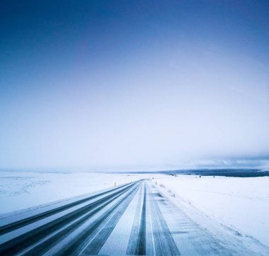 Kasvetli karlı manzara, yol ve fırtınalı gökyüzü