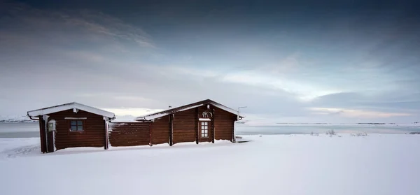 Retiro cabaña de madera en paisaje cubierto de nieve profunda — Foto de Stock