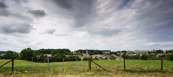 Panoramaaufnahme von Zaun in Feld mit entfernten Gebäuden — Stockfoto