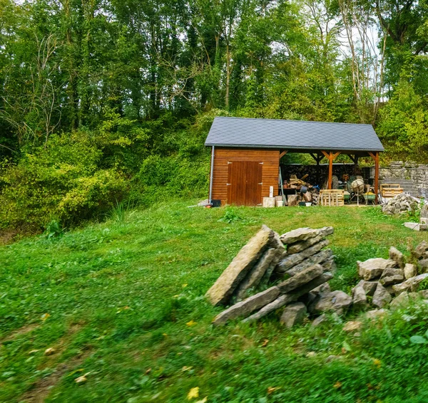 Malá dřevěná bouda se stromy za — Stock fotografie