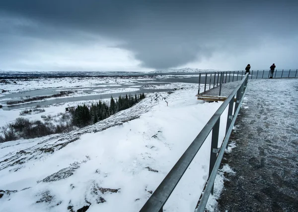 Paisagem nevada vazamento, estrada e céu tempestuoso — Fotografia de Stock