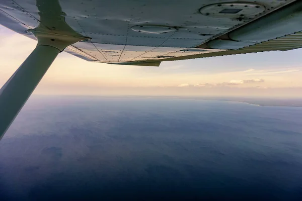 Ala de avión mirando sobre el mar — Foto de Stock