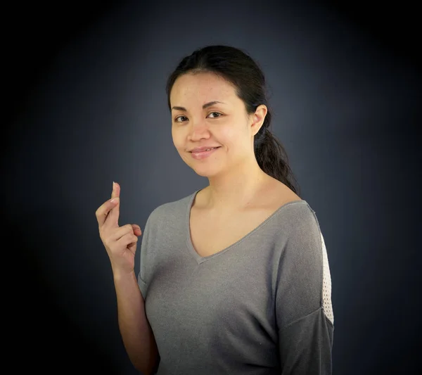 Vrouw op zoek naar camera met vingers gekruist — Stockfoto