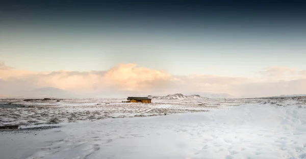 Cosy log cabin in snow covered landscape — Stock Photo, Image