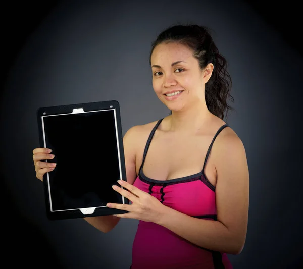 Vrouw kijken naar camera digitale tablet te houden — Stockfoto