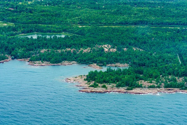 Kustlijn met bomen en offshore rotsen — Stockfoto