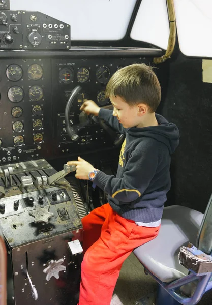 Junge im Cockpit eines stehenden Flugzeugs — Stockfoto