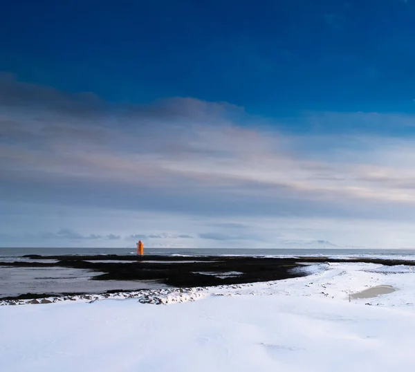 Lighthouse in distance, surrounded by sea — Stock Photo, Image