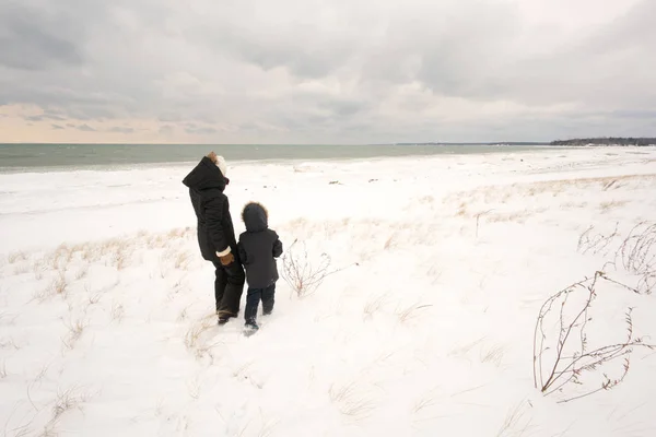 Madre e figlio a piedi nel paesaggio innevato — Foto Stock