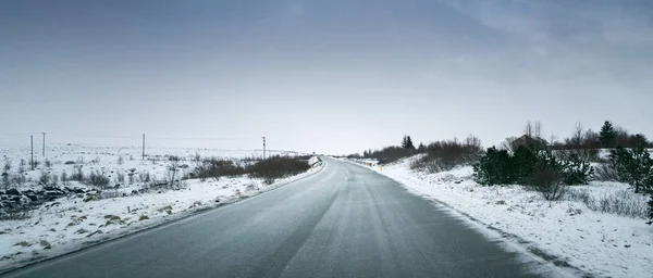 Paesaggio nevoso, strada e cielo tempestoso — Foto Stock