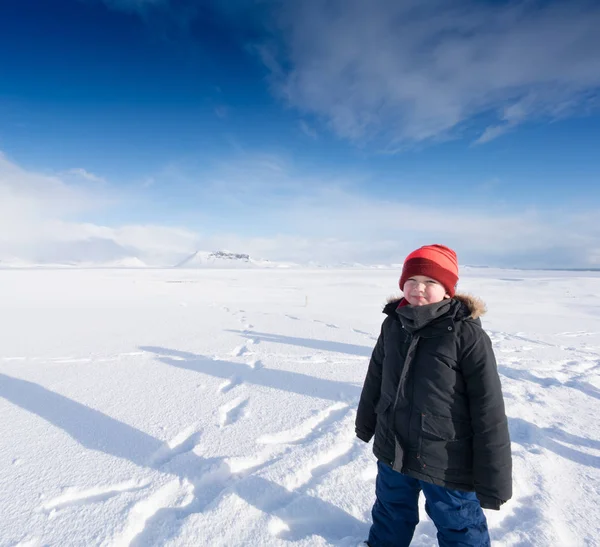 Niño de pie en el paisaje cubierto de nieve por el día — Foto de Stock