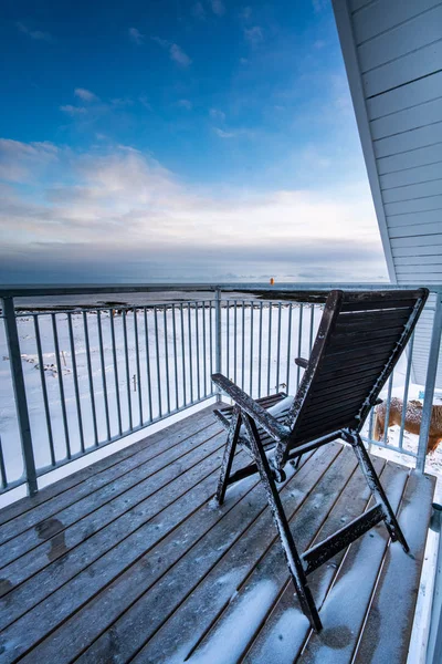Sahil tarafından ahşap veranda üzerinde duran tek şezlong — Stok fotoğraf