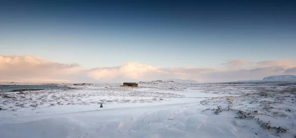 Acogedora cabaña de madera en paisaje cubierto de nieve — Foto de Stock