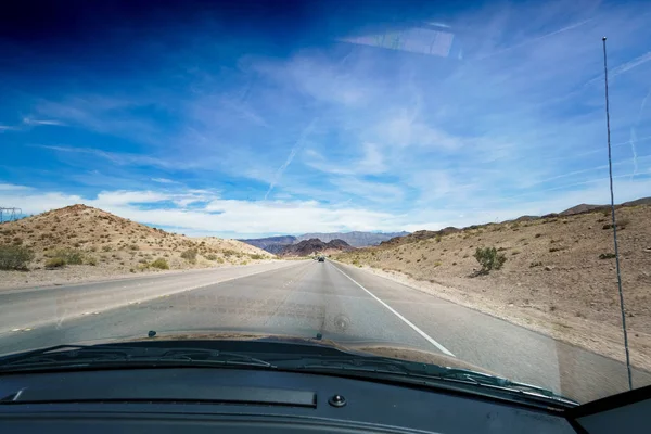 Open road in desert as seen through car windscreen — Stock Photo, Image
