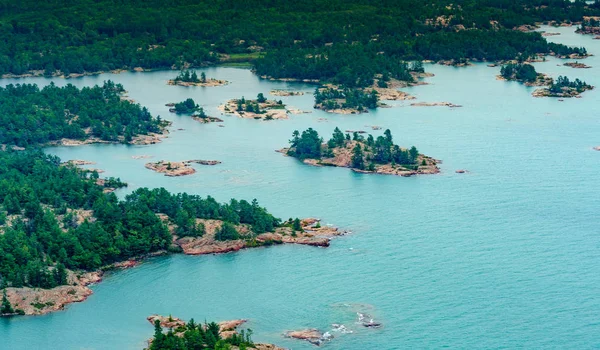 Hoge hoekmening kustlijn met offshore rotsen en bomen — Stockfoto