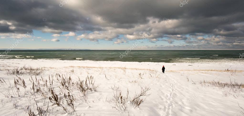 Person walking on snow covered beach