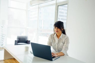 masada dizüstü bilgisayar kullanan genç kadın