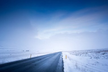 Kasvetli karlı manzara, yol ve fırtınalı gökyüzü