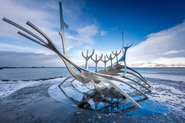 Boynuz şekil heykel dairesel kaldırım üzerinde konumlandırılmış
