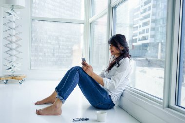 Genç kadın cep telefonu aşağı bakıyor