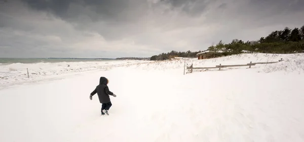 Criança andando na neve na paisagem coberta de neve — Fotografia de Stock