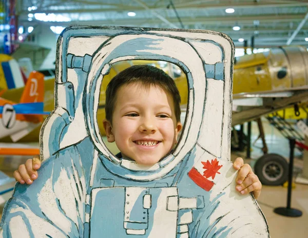 Cabeza de niño sonriendo con la cabeza a través de astronauta recortado —  Fotos de Stock