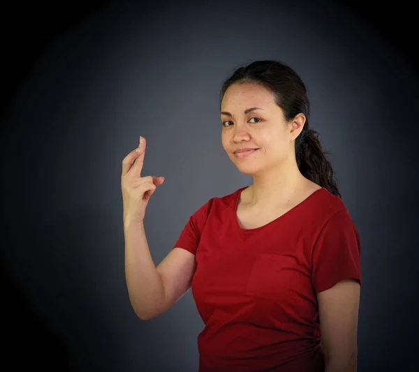 Woman looking at camera with fingers crossed — Stock Photo, Image