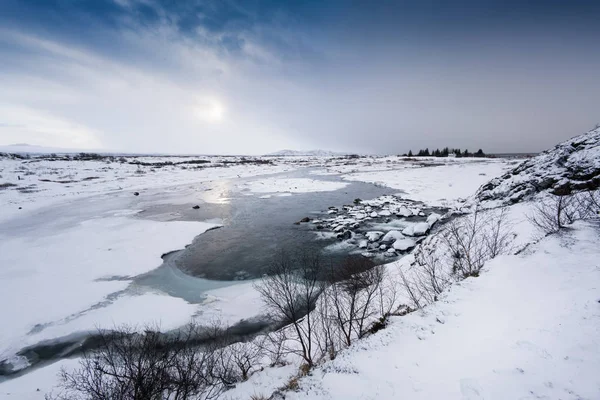 Zugefrorener See und verschneite Landschaft — Stockfoto