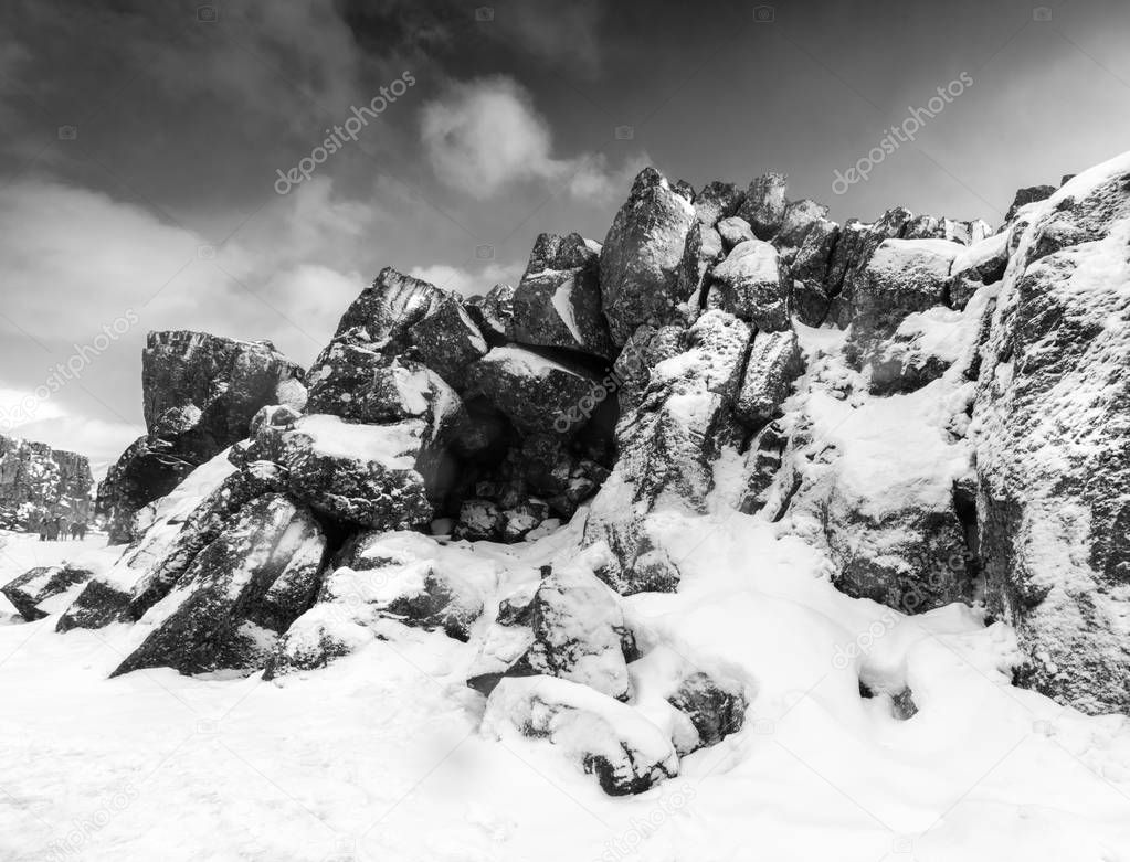 Snow covered rock formations by stream and sky