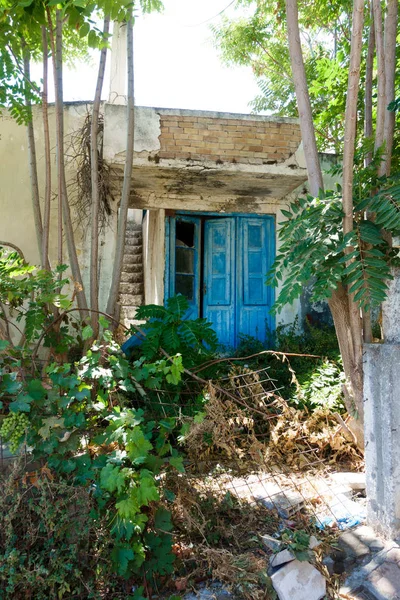 Old ruined house front door with plants and trees, Crete, Greece