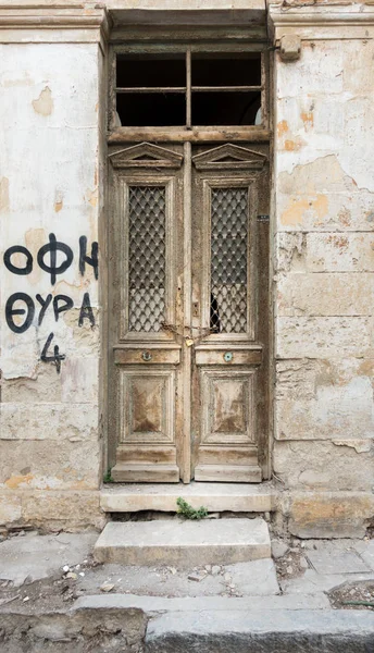 Old ruined wooden door and weathered wall, Heraklion, Greece
