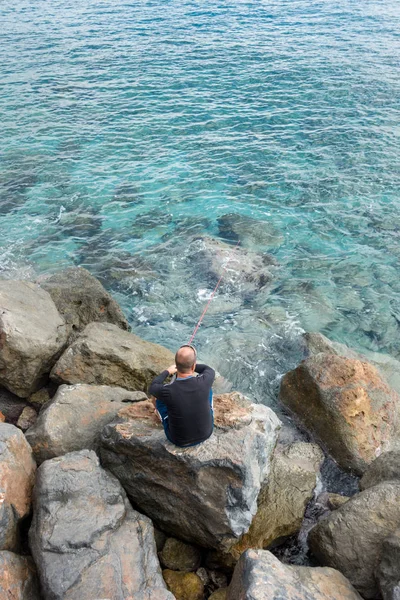 岩の多い海岸線から釣り人 — ストック写真