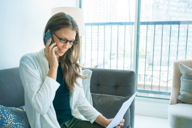 Belge tutarak ve cep telefonu üzerinde konuşurken genç kadın