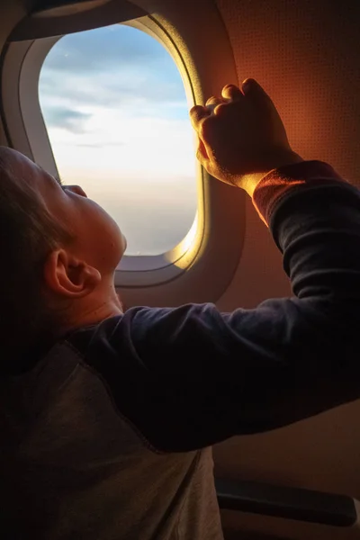 Anak Kecil Yang Ingin Tahu Mengawasi Langit Melalui Jendela Pesawat — Stok Foto