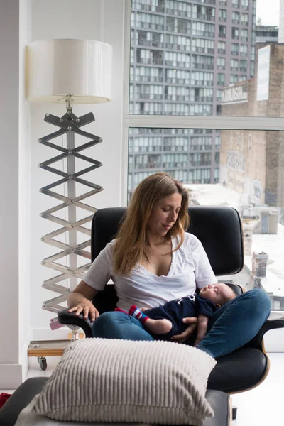 リクライニング肘掛け椅子自宅で寝ている赤ん坊と母親 — ストック写真
