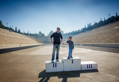Father and son standing on winner's podium at Panathinaiko Stadium, Athens, Greece, Europe clipart
