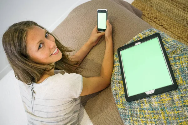 携帯電話とデジタル タブレットのベッドで幸せな若い女 — ストック写真