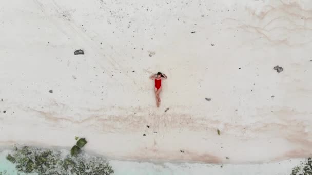 Meisje in een badpak ligt op het strand — Stockvideo