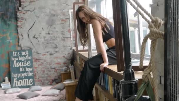 Chica sentada en el alféizar de la ventana y posando — Vídeos de Stock