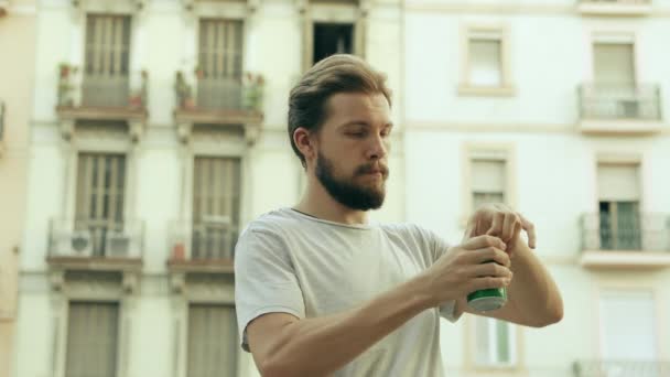 Jeune homme beau ouvre une canette de boisson et de boissons — Video