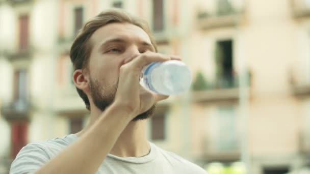 Jovem Thisty Man bebe e desfruta de uma garrafa de água fria — Vídeo de Stock