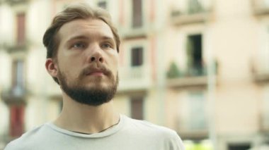 Genç Thisty Man bir şişe soğuk su içiyor ve eğleniyor.