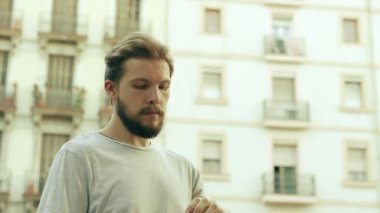 Genç Thisty Man bir şişe soğuk su içiyor ve eğleniyor.