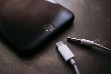 Nizhyn, Ukrayna / 26 Kasım 2019: iphone 7 Plus ve yıldırımlı kulaklıklar ve 3.5 mm 'lik kriko çıktıları. Elma yeni yıldırım konsepti