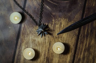Nizhyn, Ukrayna / 22 Aralık 2019: Flatlay, cadı Geralt 'ın madalyon, bıçak ve mumlarına ahşap zemin üzerinde yakın plan. Yeni Netflix Tv dizisi 